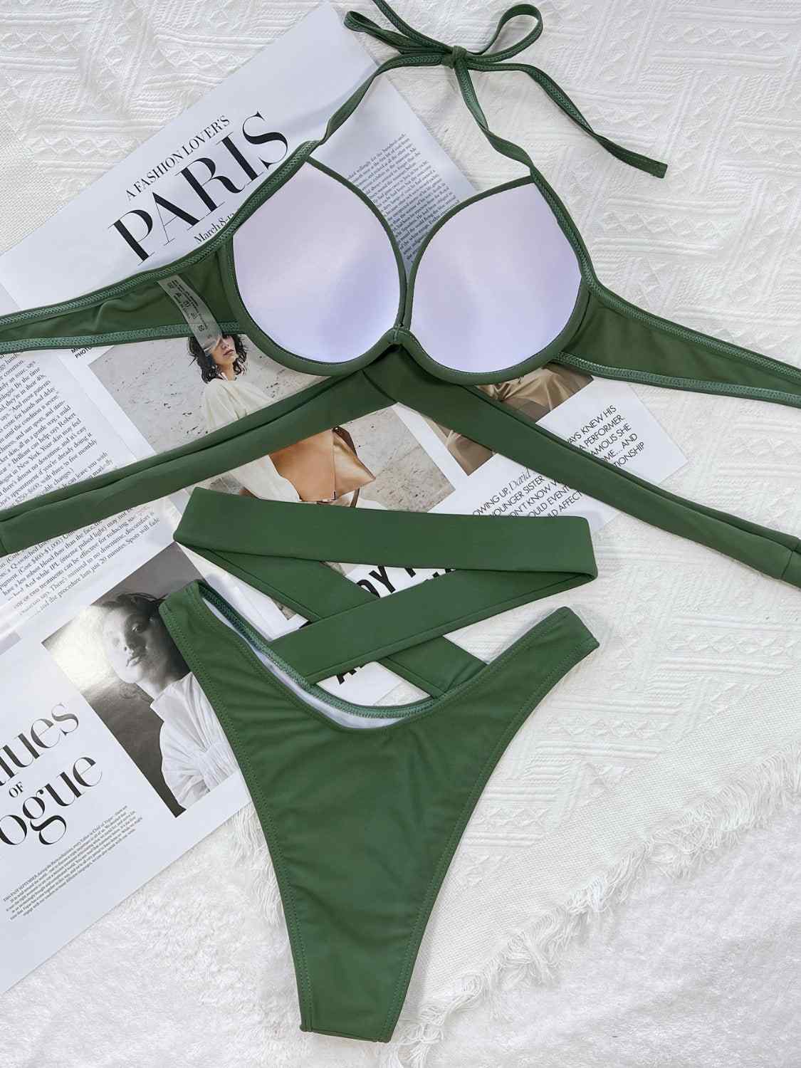 Crisscross halter neck bikini set with ruched design, removable padding, and stretchy green fabric.