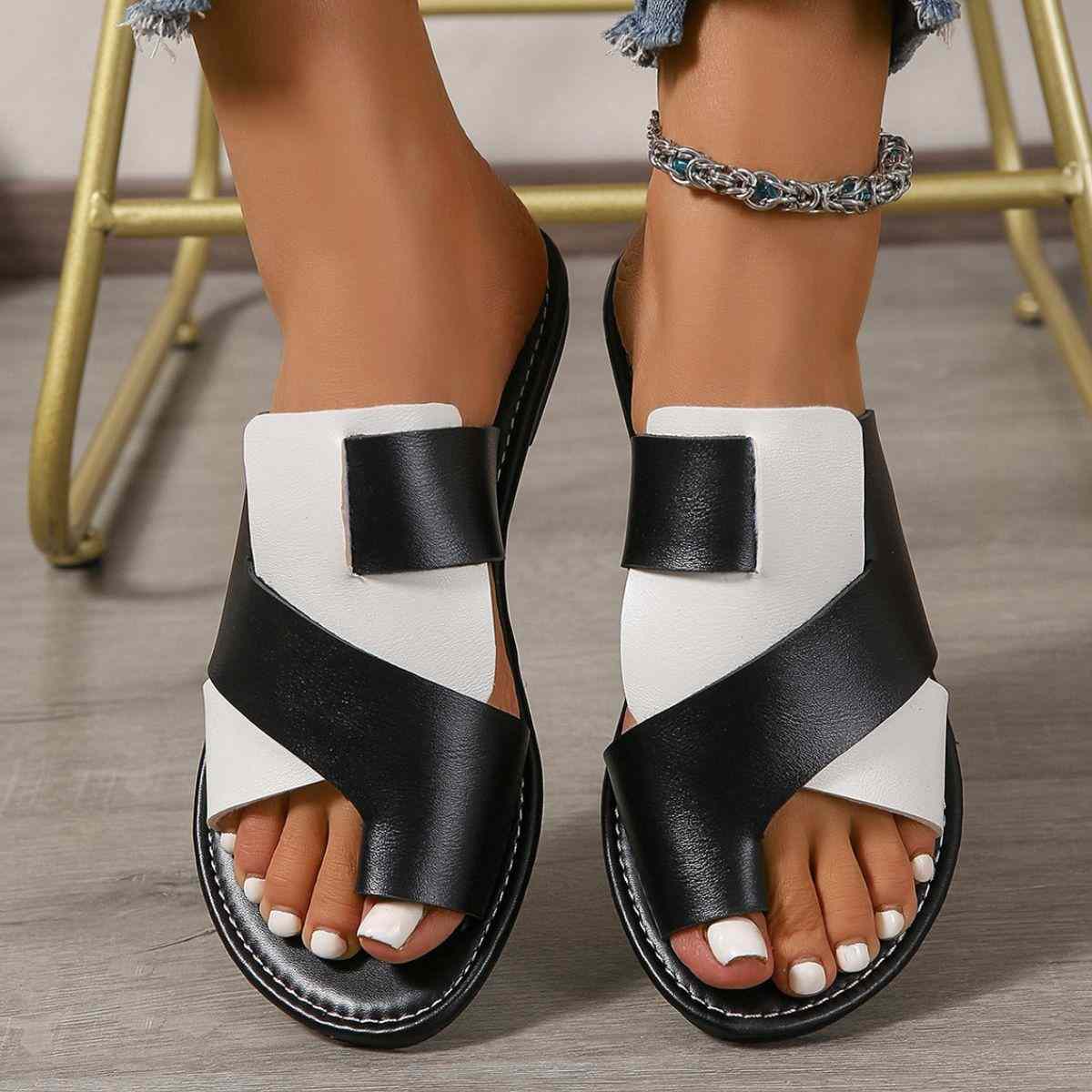Black and white toe post flats sandals, rubber and artificial PU material, featuring a crisscross design.