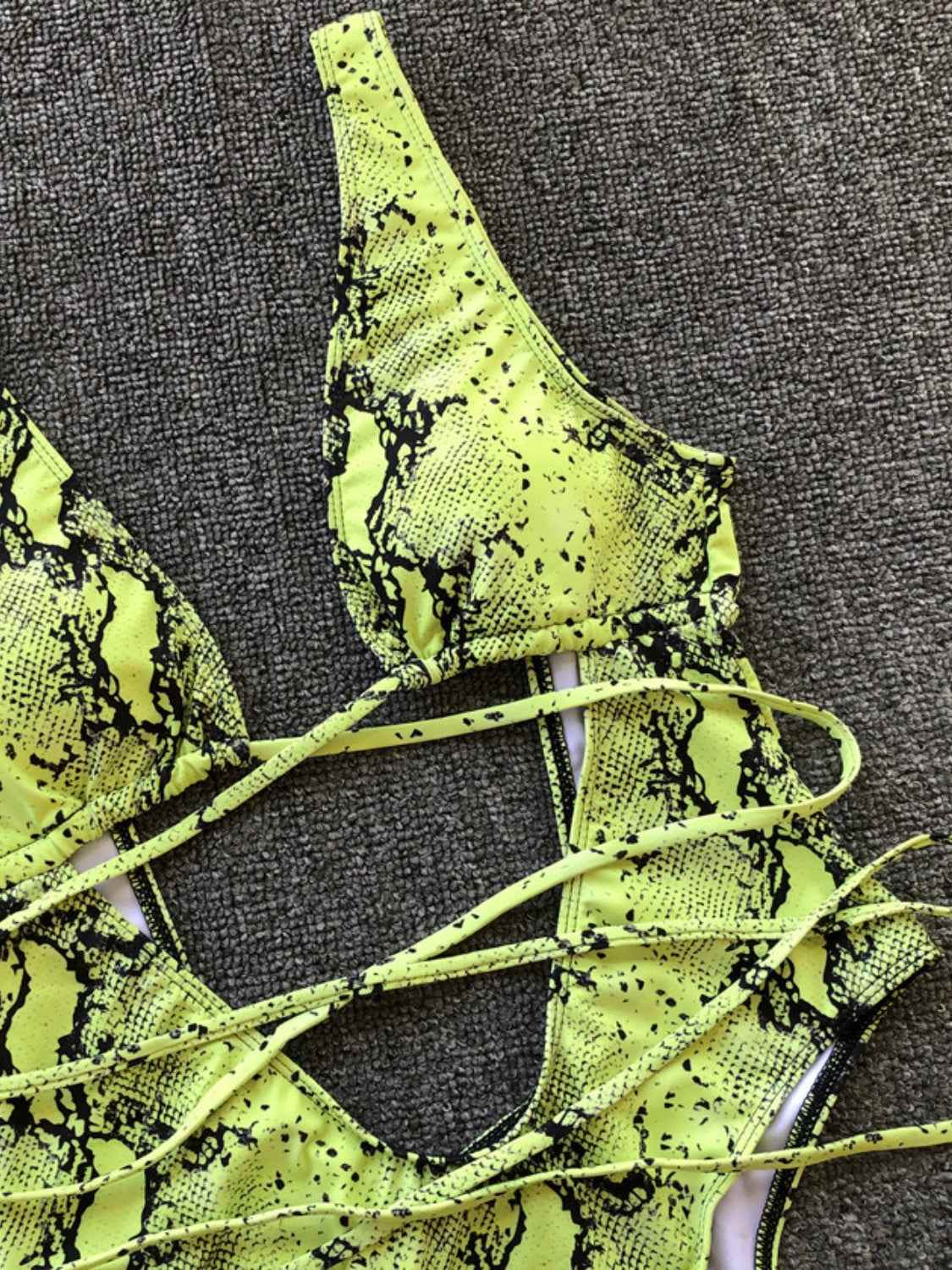 Lace-up backless one-piece swimwear in green snake print with adjustable ties.