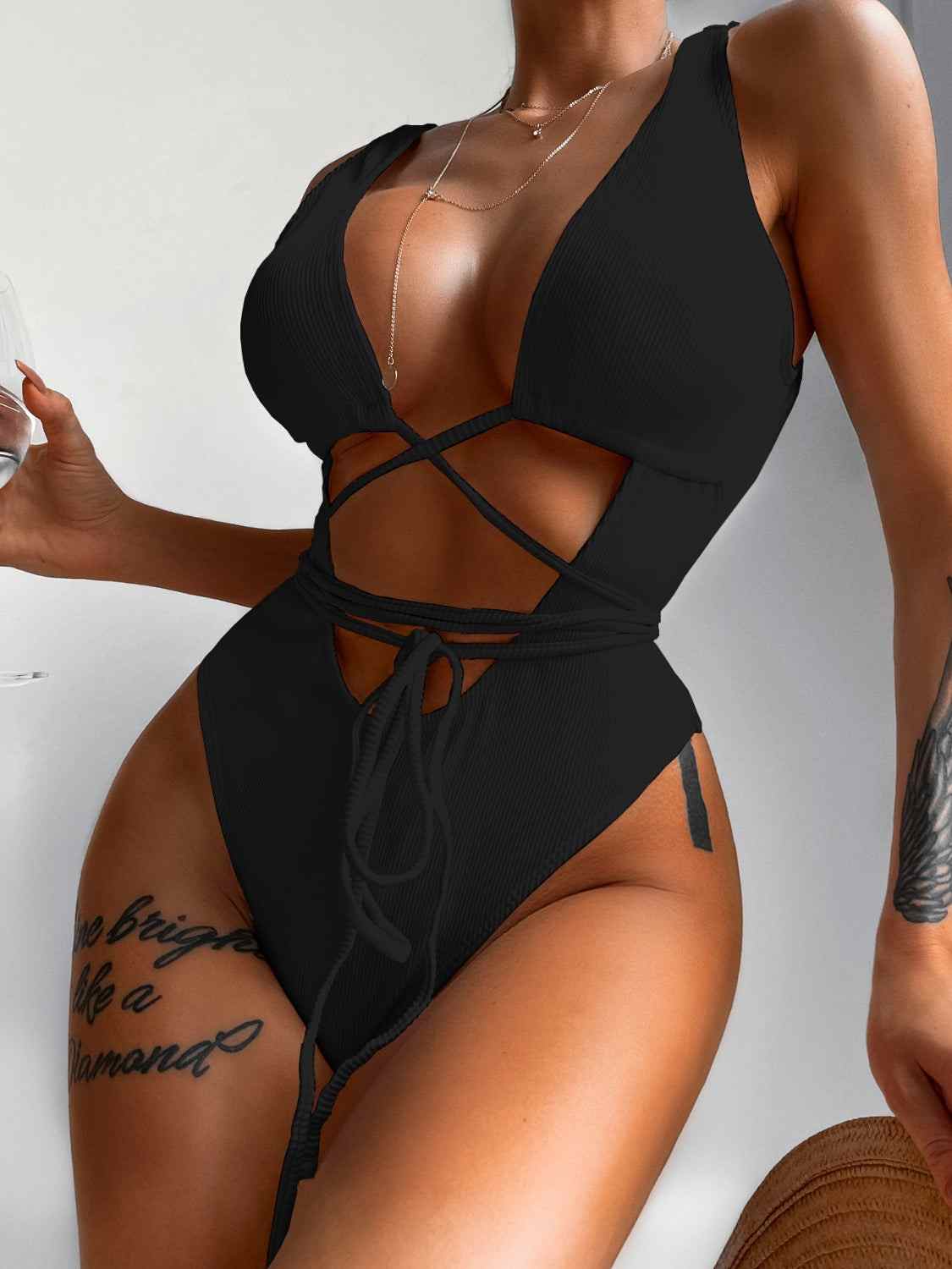 Ribbed lace-up one-piece swimsuit with removable padding and stretchy material.