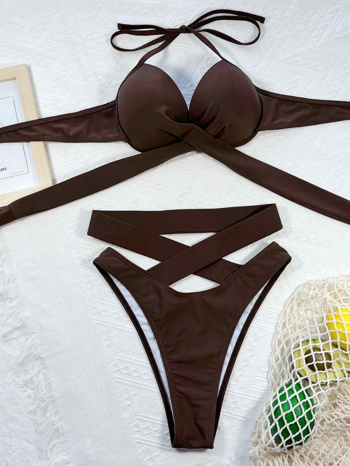Crisscross halter neck bikini set with ruched design, removable padding, and stretchy fabric.