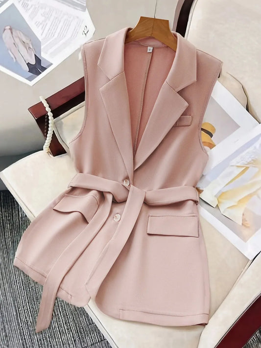 Sleeveless pink blazer with tie waist and lapel collar made of polyester.