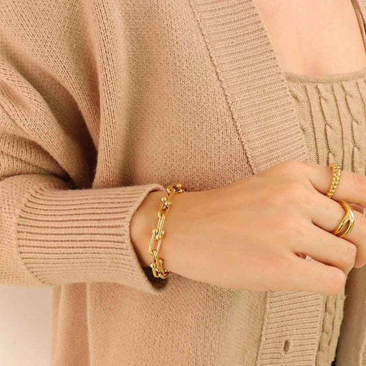 Chunky chain titanium steel bracelet in gold on wrist.