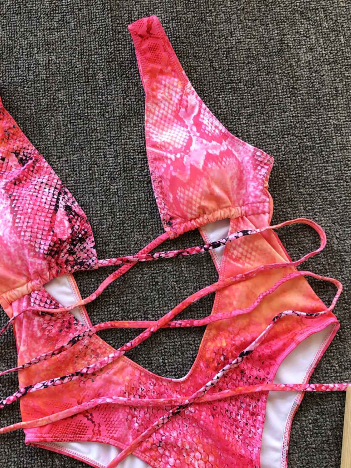 Lace-up backless one-piece swimwear with plunge neckline and pink snake print.