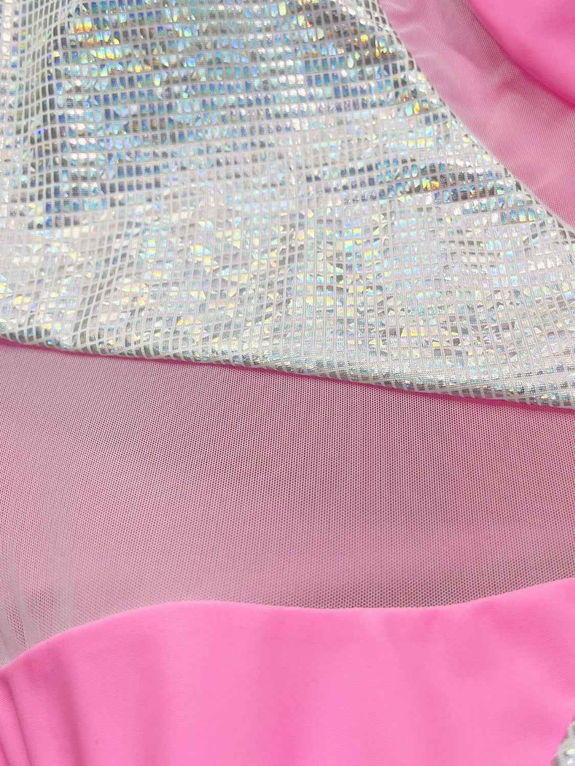 Contrast panel design on a pink one-piece swimsuit featuring a sparkly metallic shimmer.