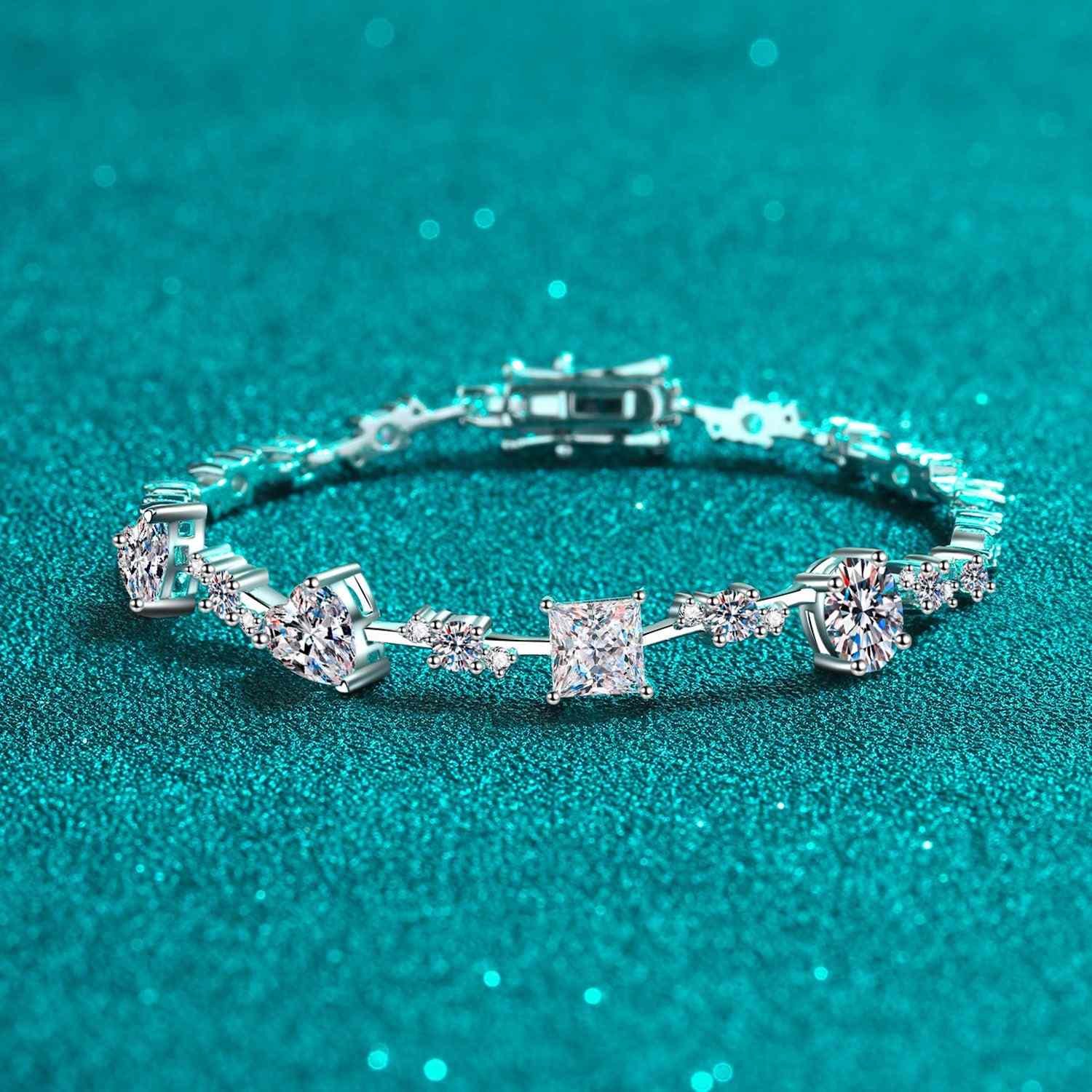 6.2 Carat Moissanite 925 sterling silver bracelet with diverse stone cuts on a shimmering teal background.