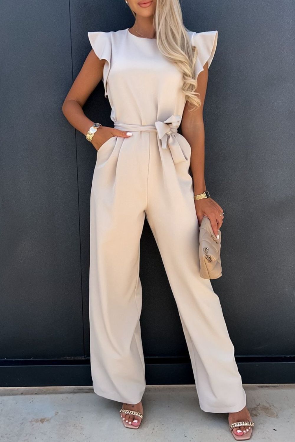 Round neck cap sleeve jumpsuit with tied waist in beige.