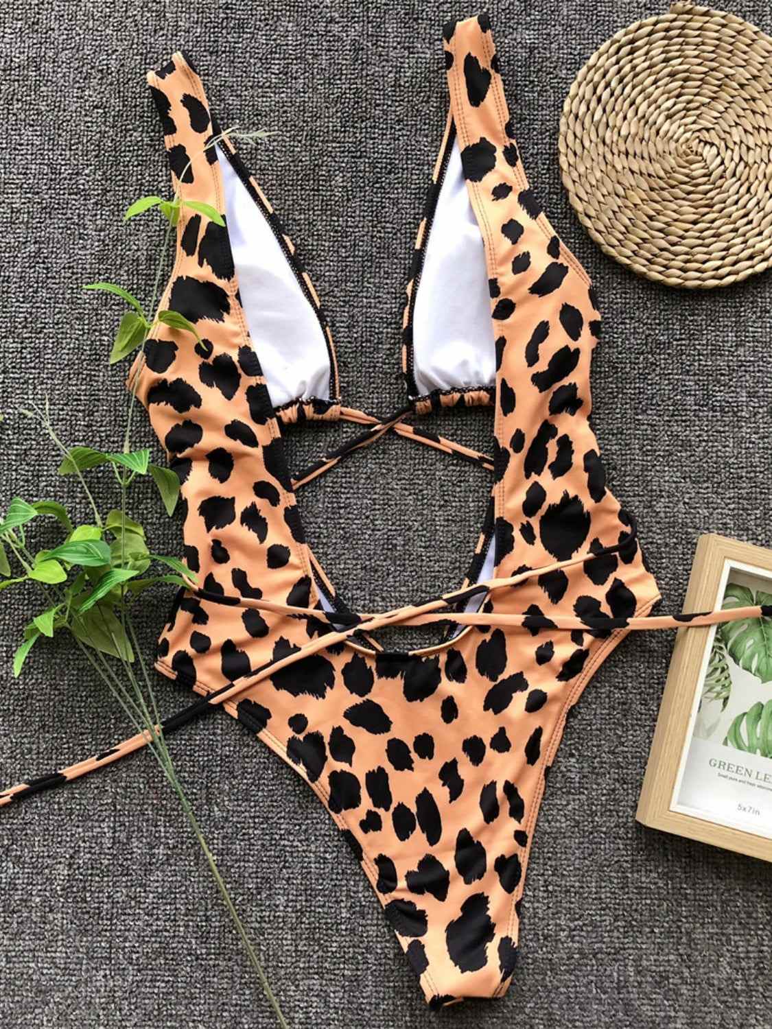 Lace-up backless plunge one-piece swimwear with leopard print pattern.