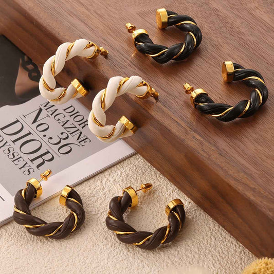 Twisted Leather Rope C-Hoop Earrings with 18K gold-plated accents displayed on a wooden surface.