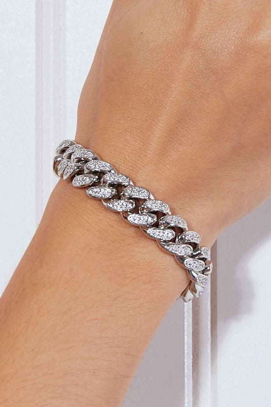 Curb chain bracelet made of brass on a wrist in studio flat lay style.