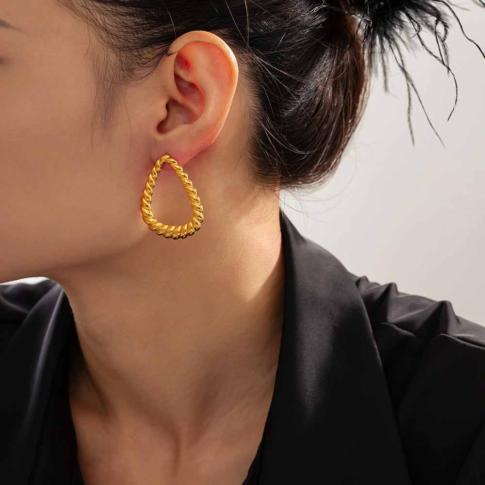 18K gold-plated twisted earrings on ear, elegant design.